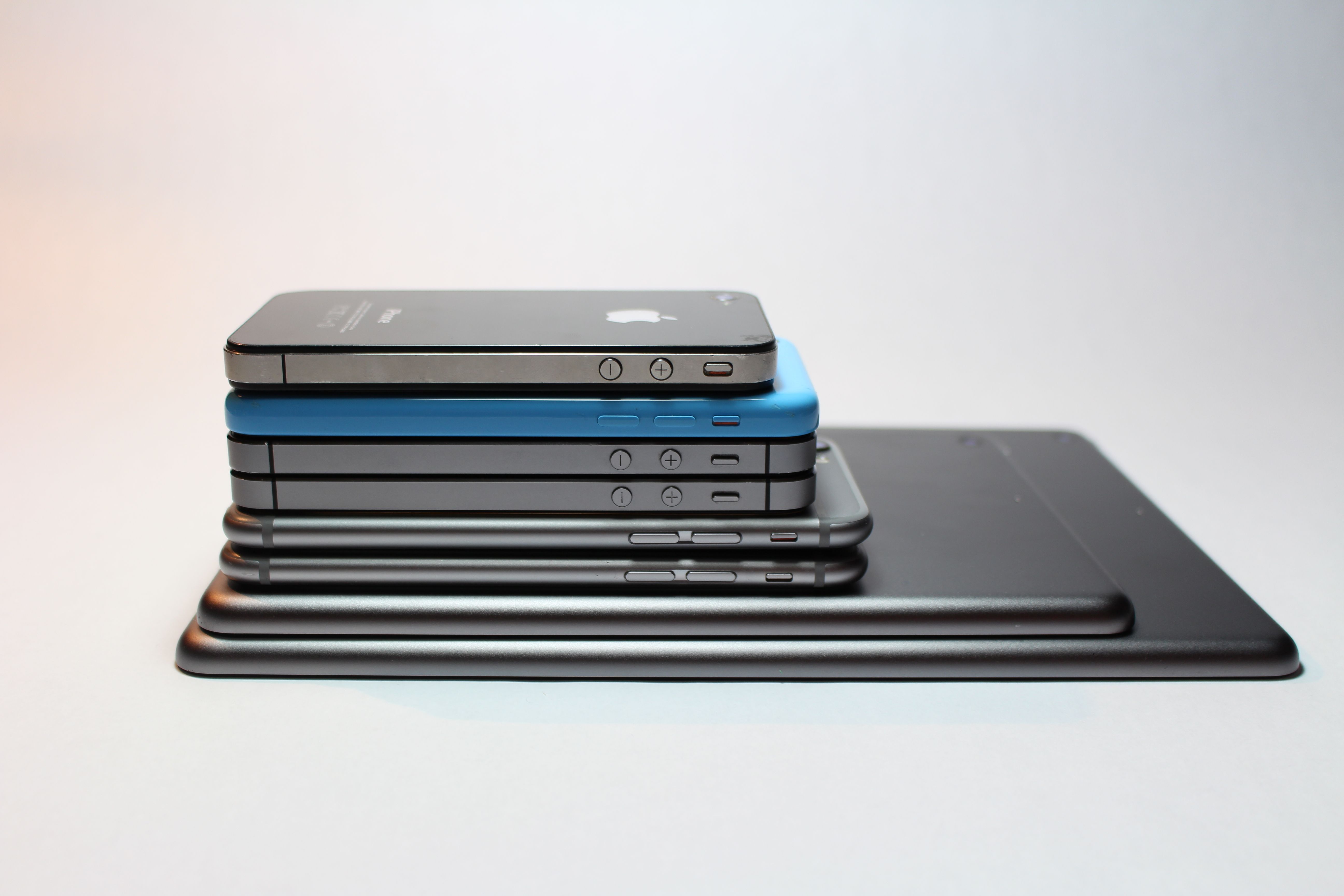 A stack of Apple devices seen from the side